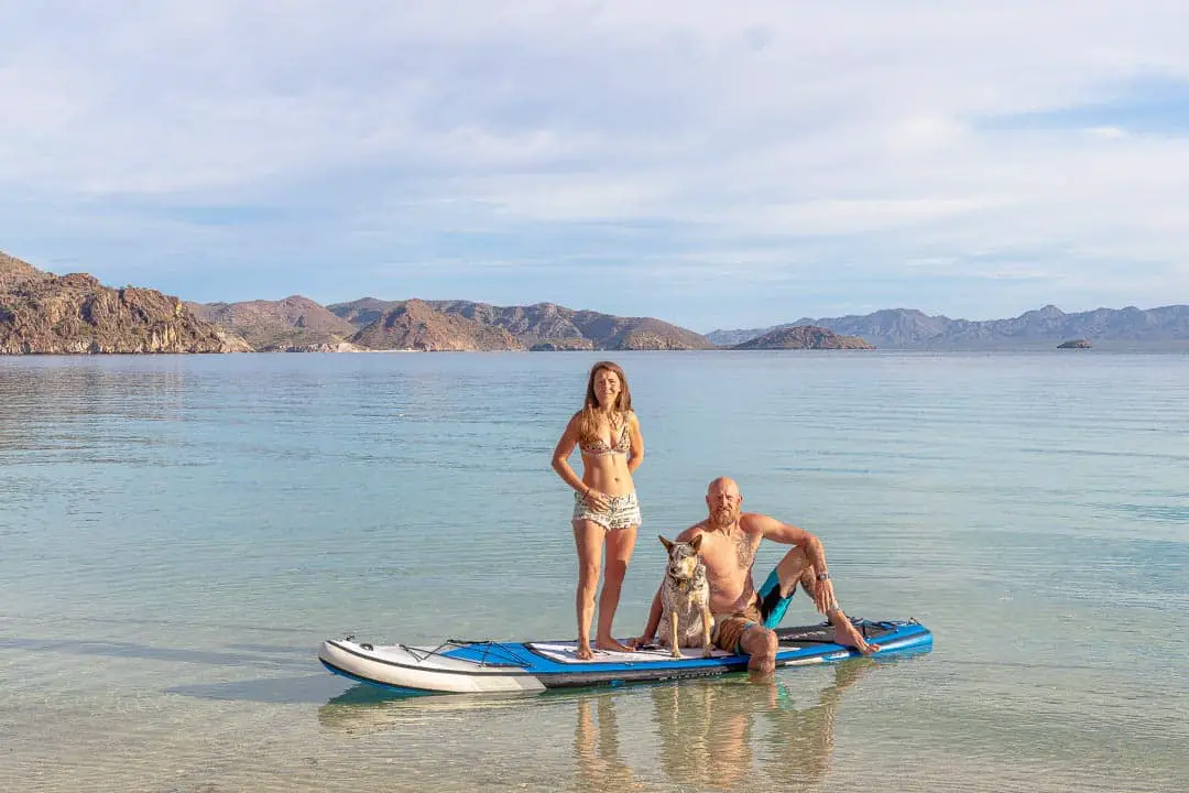 Couple with dog on a paddleboard in the ocean